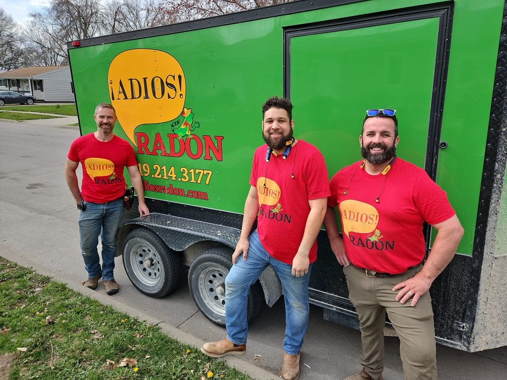 Adios Radon team members standing in front of company trailer