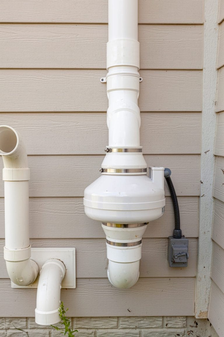 Stock image of a radon mitigation system on a home.